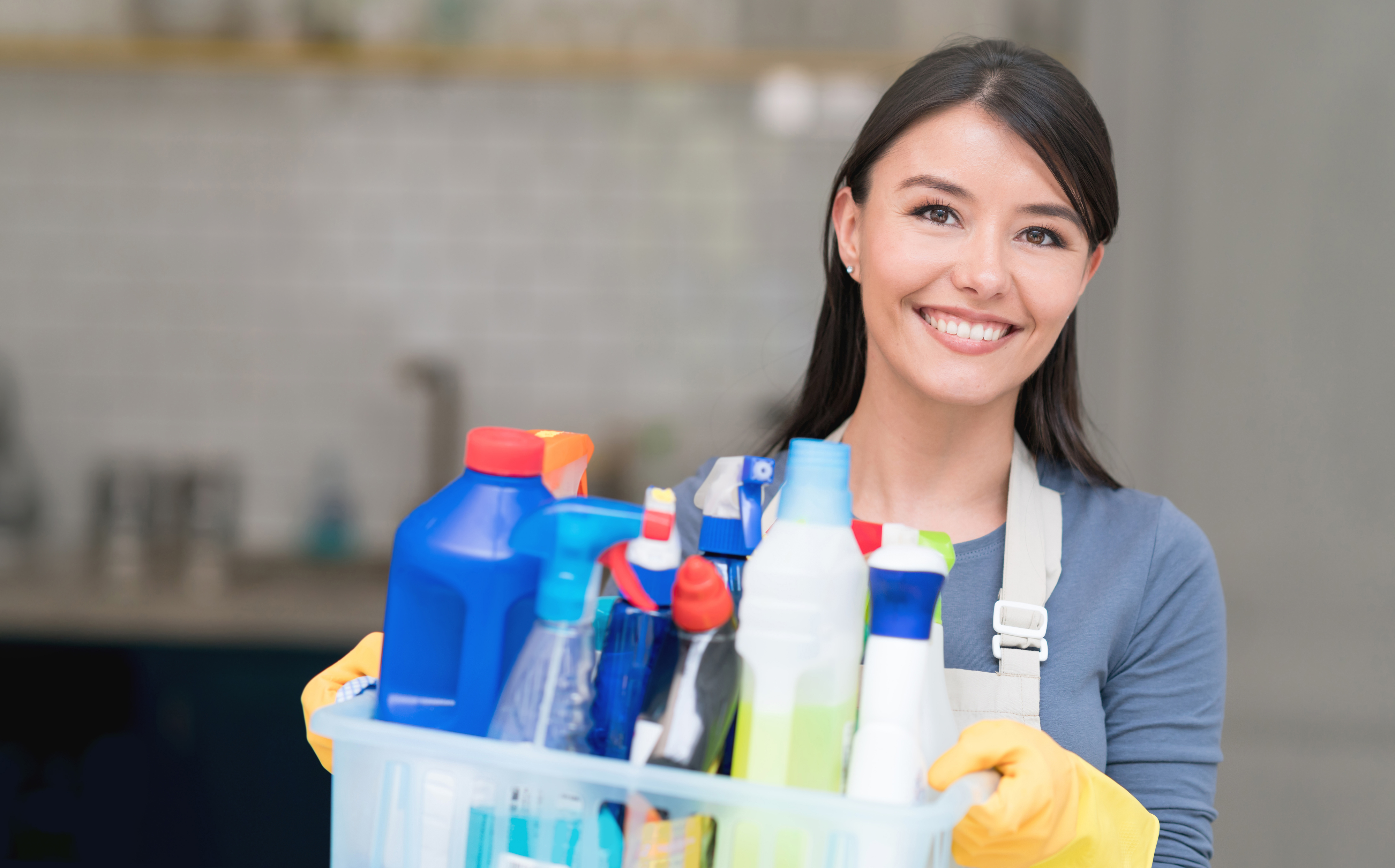 Woman holding onto cleaning supplies