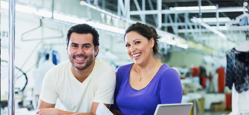 Two laundromat owners stand at front desk