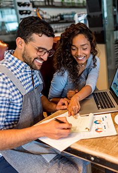 Happy business owner helping an employee