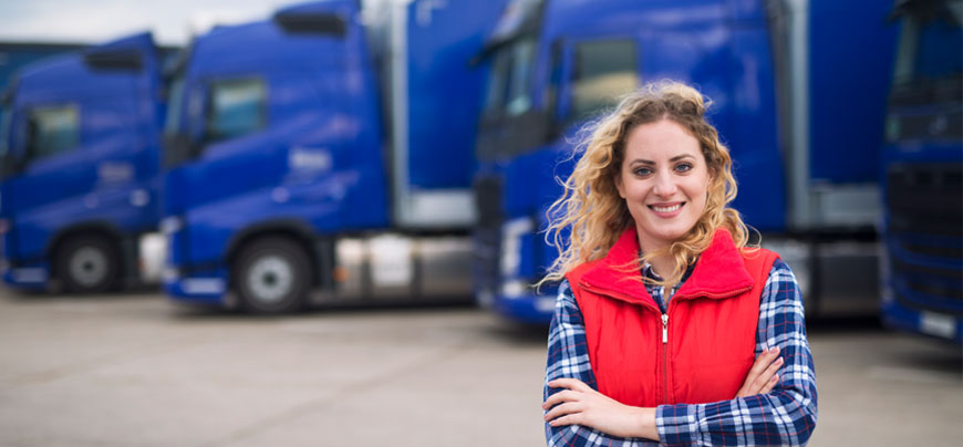 Truck driver stands in front of their vehicle