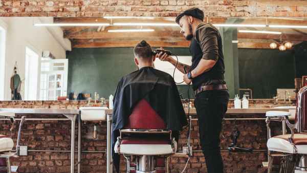 Professional barber cutting client's hair