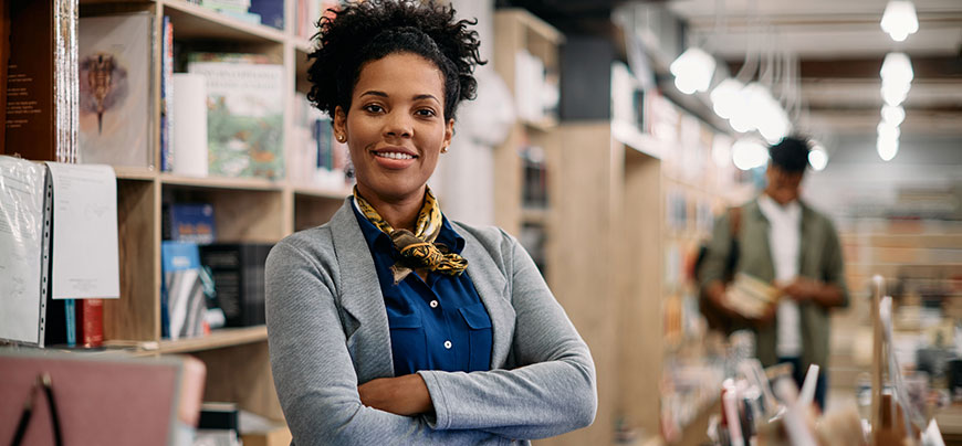 Woman poses in front of bookshelf