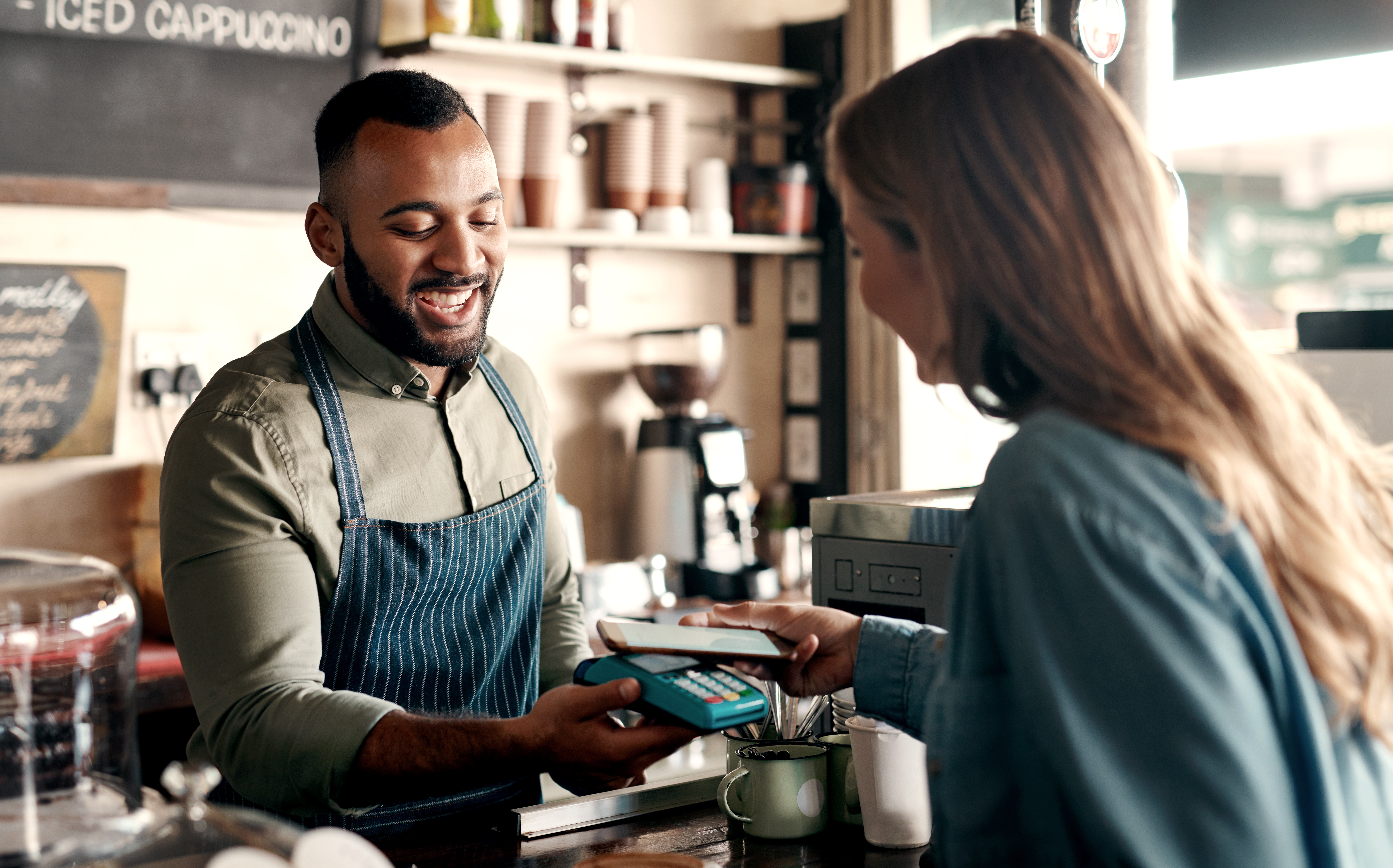 Woman paying at the counter using tap to pay