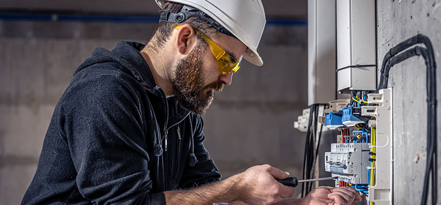 Electrician works on control panel