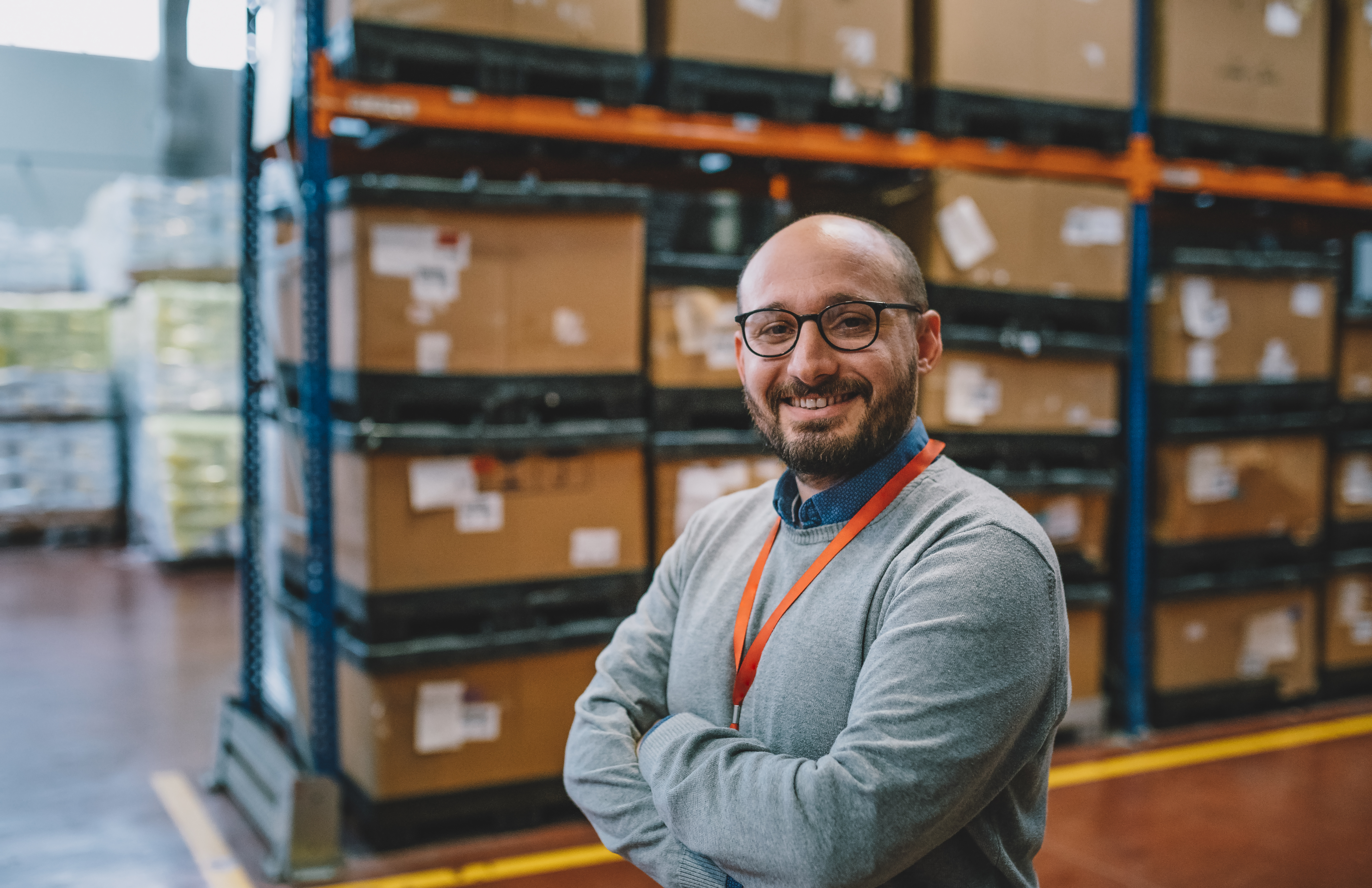 Man stands in front of shelves full of packages