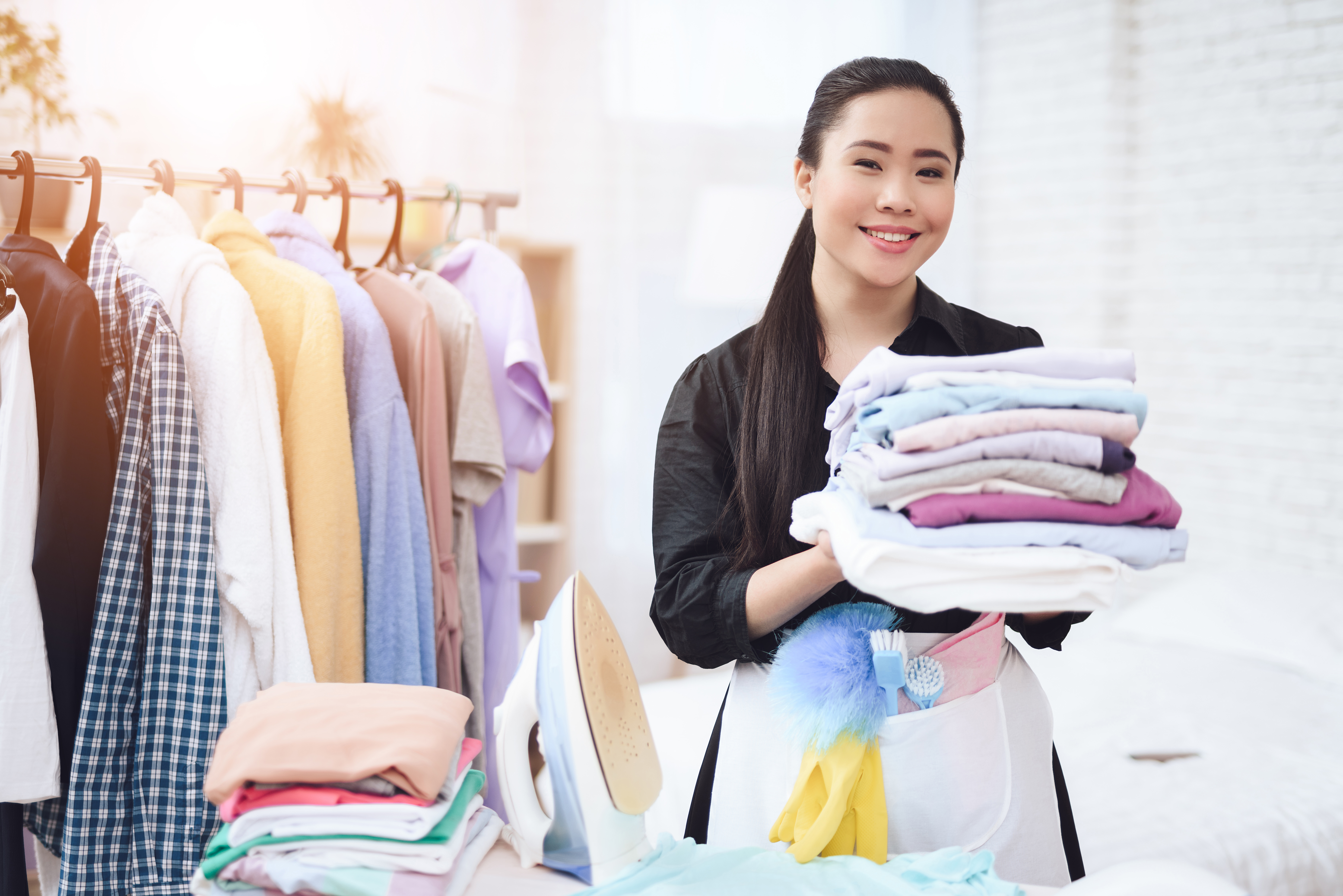 Laundry service worker with stack of clothes 