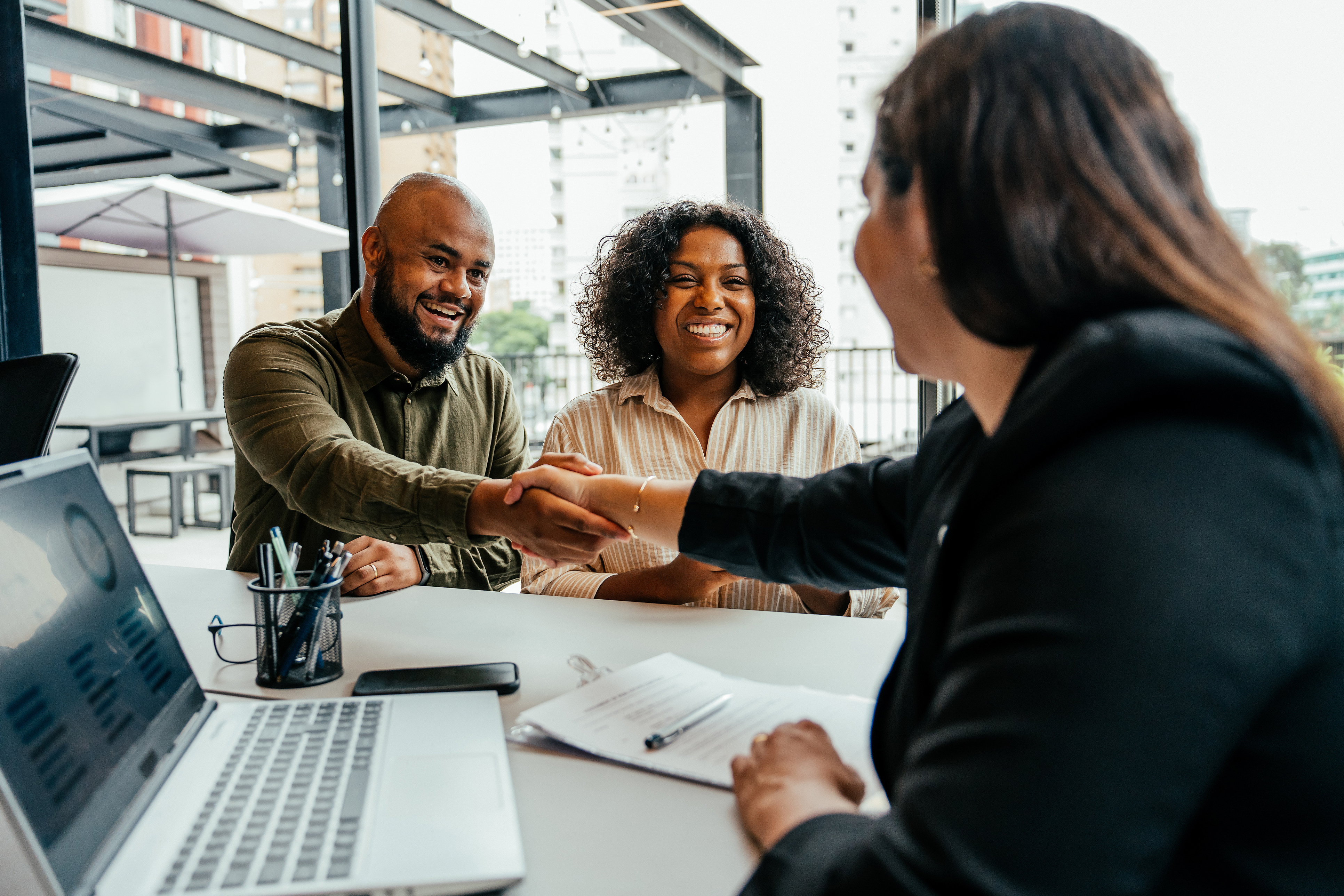 Couple closing real estate contract with real estate agent