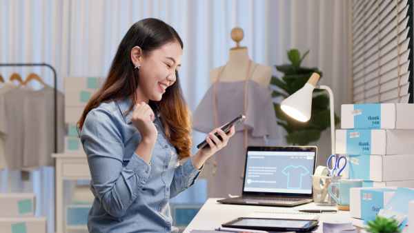 Fashion designer using internet on phone